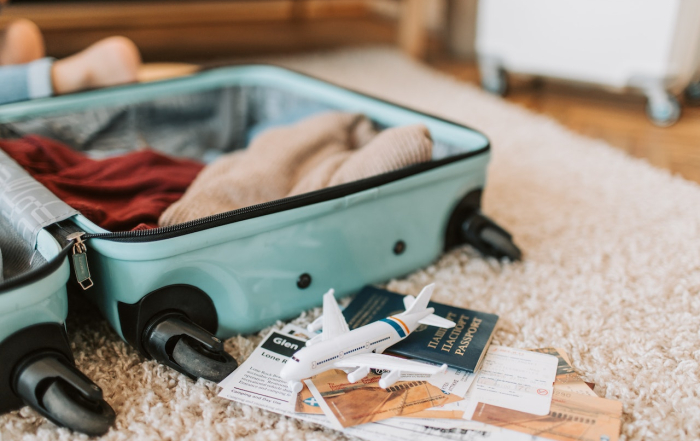 Maleta de viaje con ropa y billetes de avión.