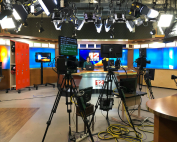 Presentadora de televisión en el plató de informativos con todo el material técnico.