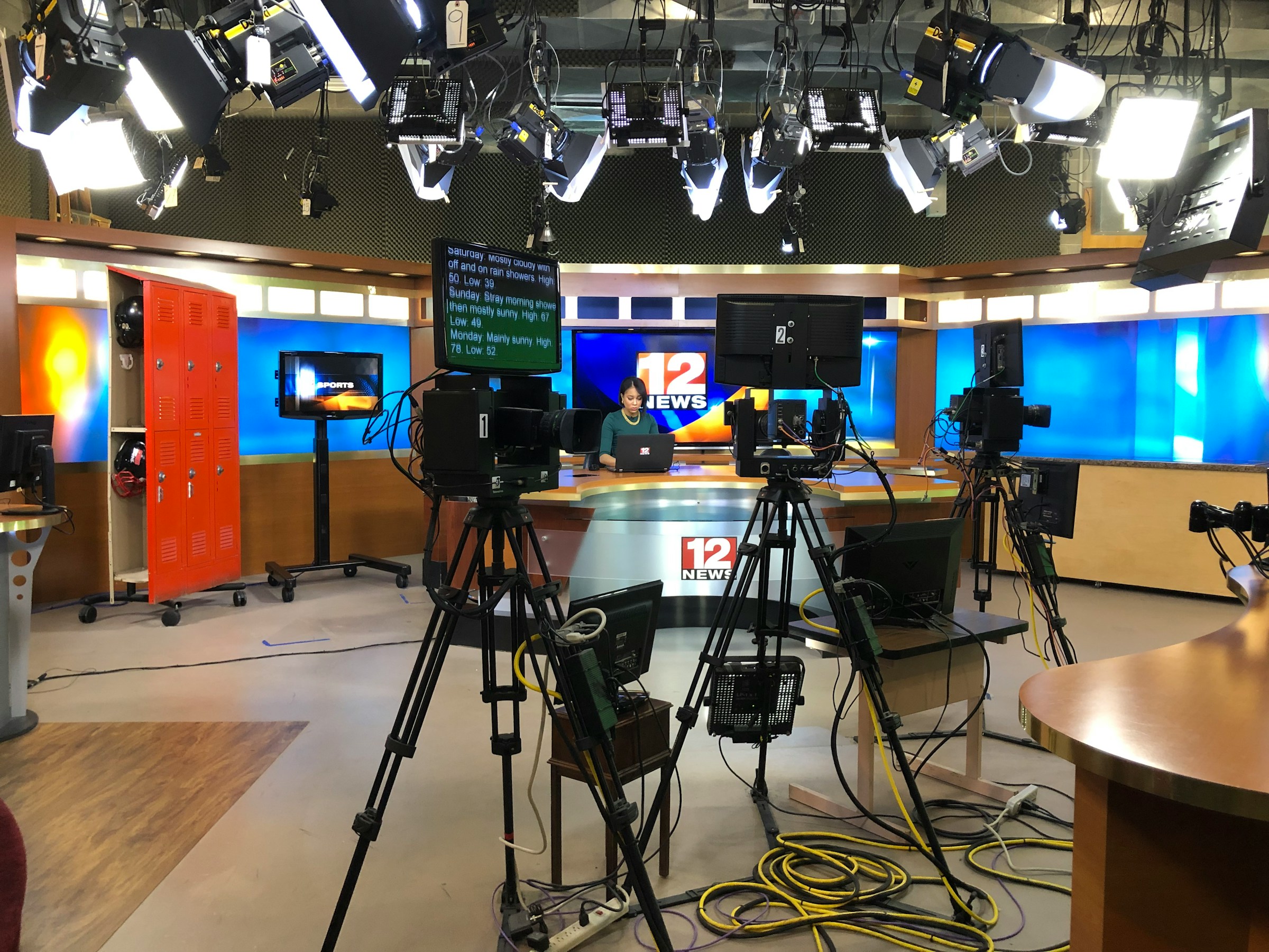 Presentadora de televisión Presentadora de televisión en el plató de informativos con todo el material técnico.