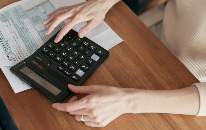 Mujer realizando operaciones con una calculadora.