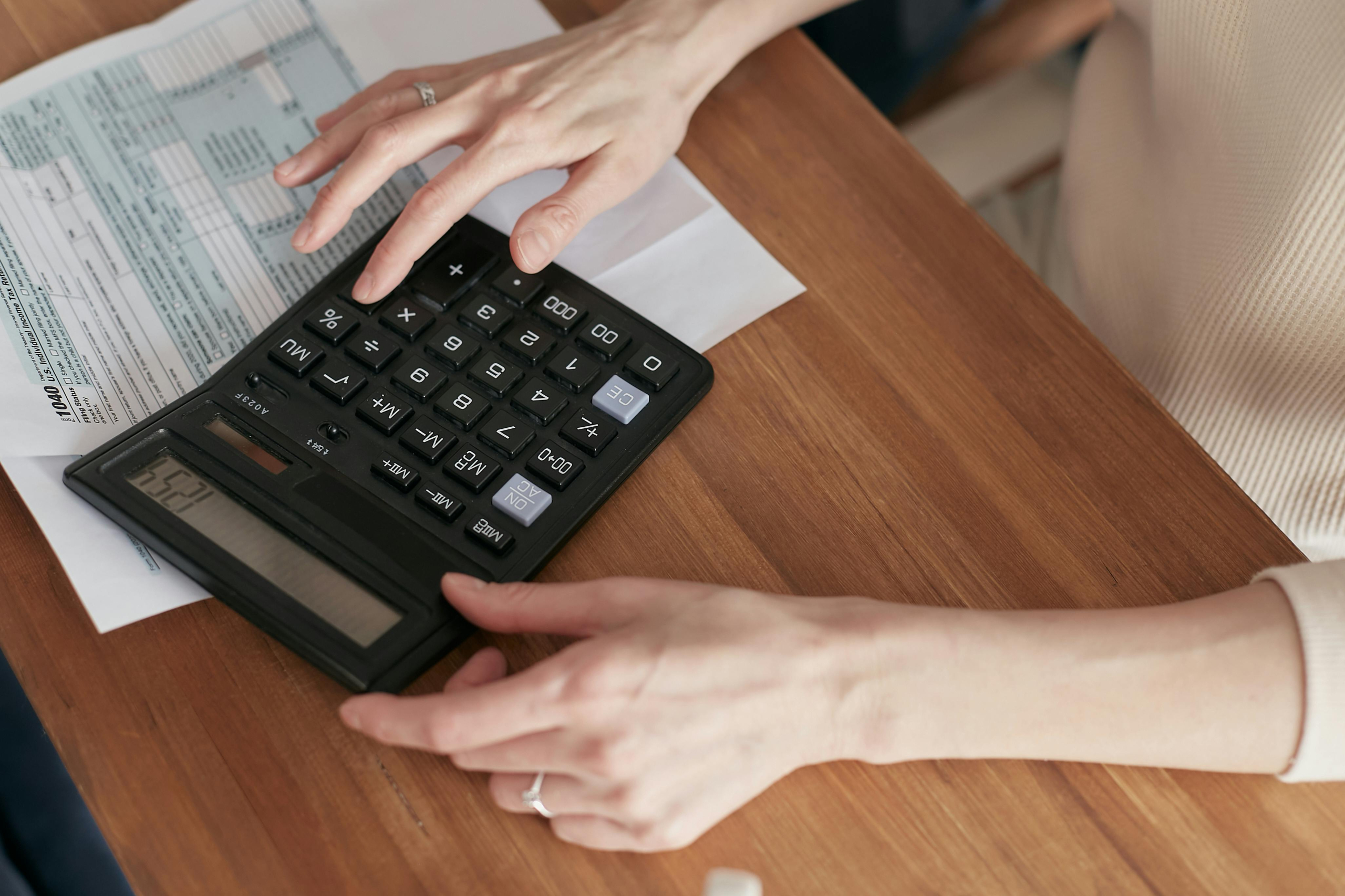 Mujer realizando operaciones con una calculadora.