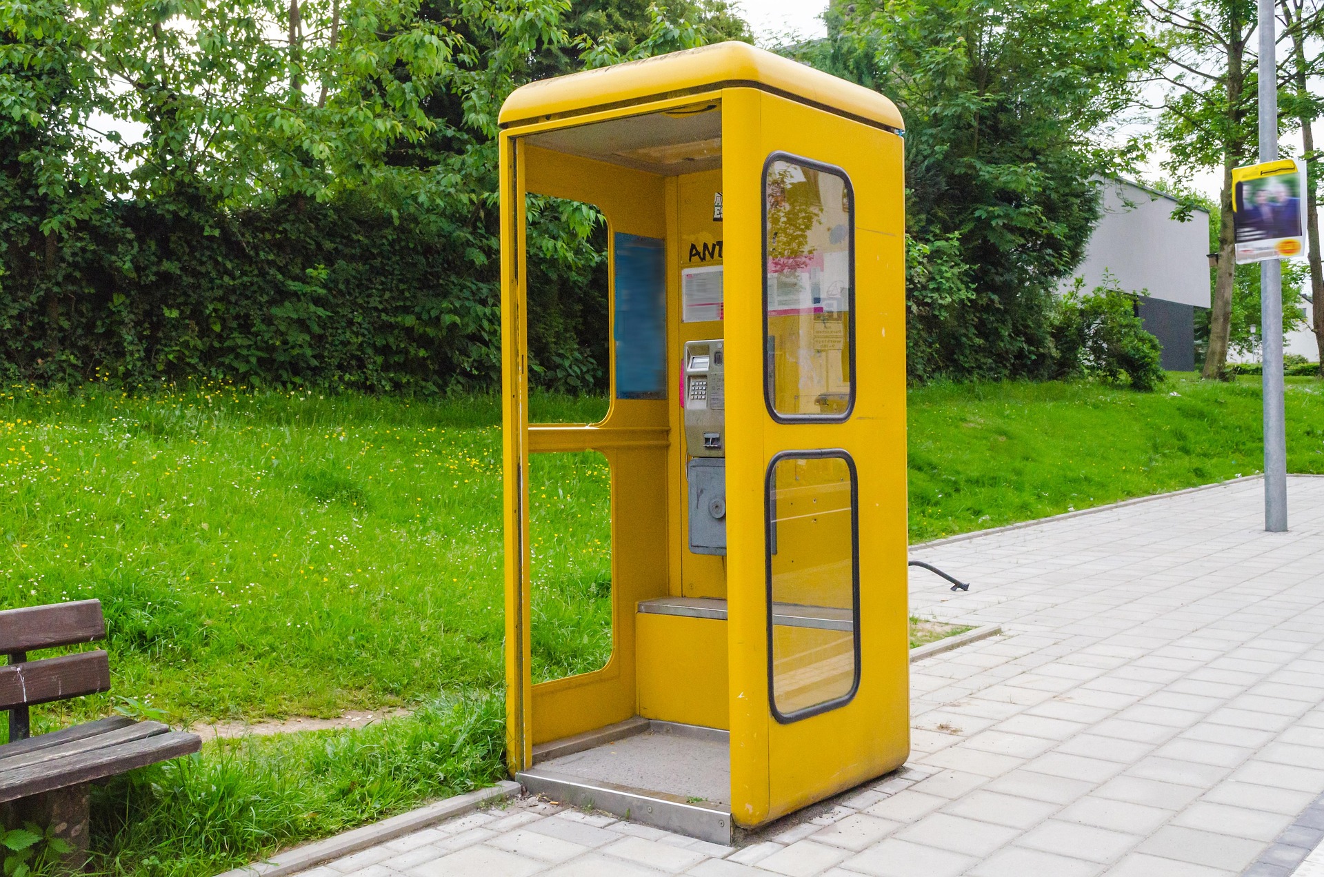 Cabina de teléfono Cabina de teléfono amarilla en medio de la calle.