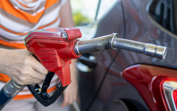 Hombre con una maguera de gasolina en la mano.