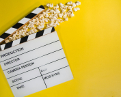 Claqueta y palomitas sobre fondo amarillo