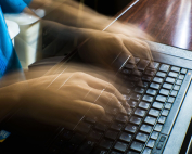 Manos moviéndose rápido sobre el teclado del ordenador