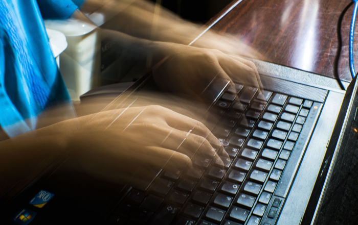 Manos moviéndose rápido sobre el teclado del ordenador